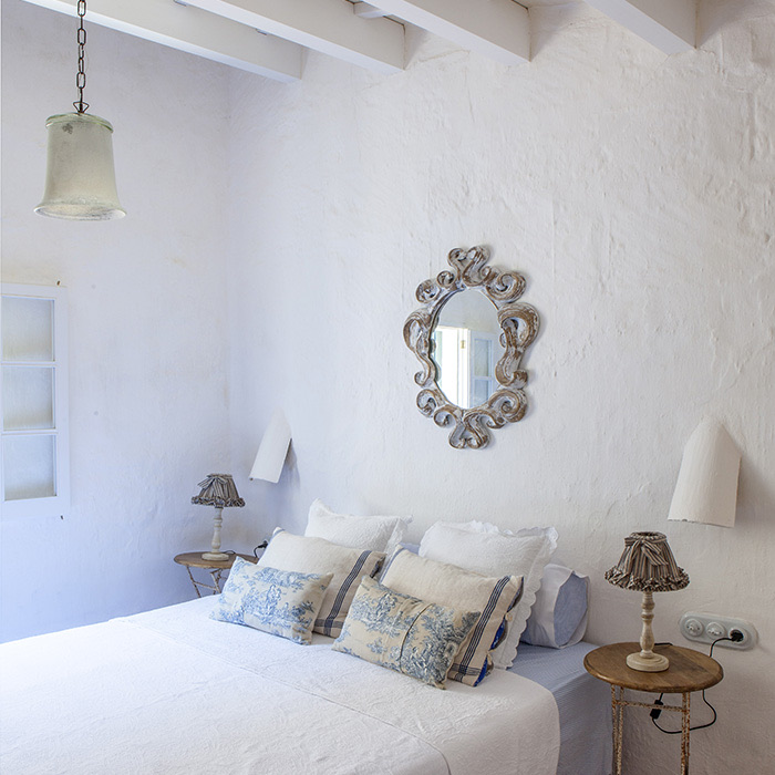 Ciutadella Menorca, Spain: Evelyne Mandel House - Classic Bedroom In White - Bed, Blue And White Cushions, Antique French Wooden Mirror, Lamps And Bedside Tables