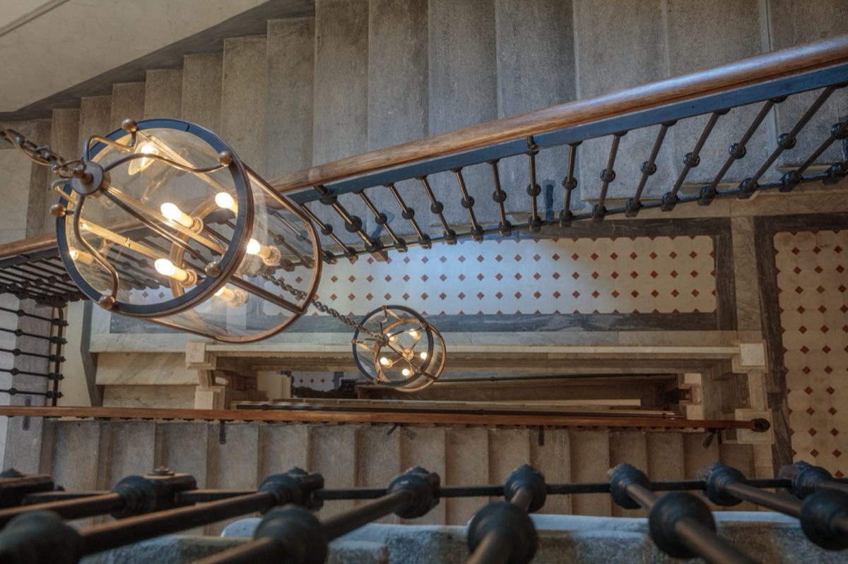 Lanterns hanging in the palazzo's stone stairwell, seen from below